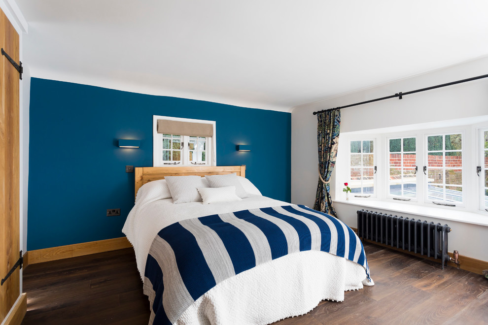 На фото: хозяйская спальня среднего размера в стиле неоклассика (современная классика) с синими стенами и темным паркетным полом