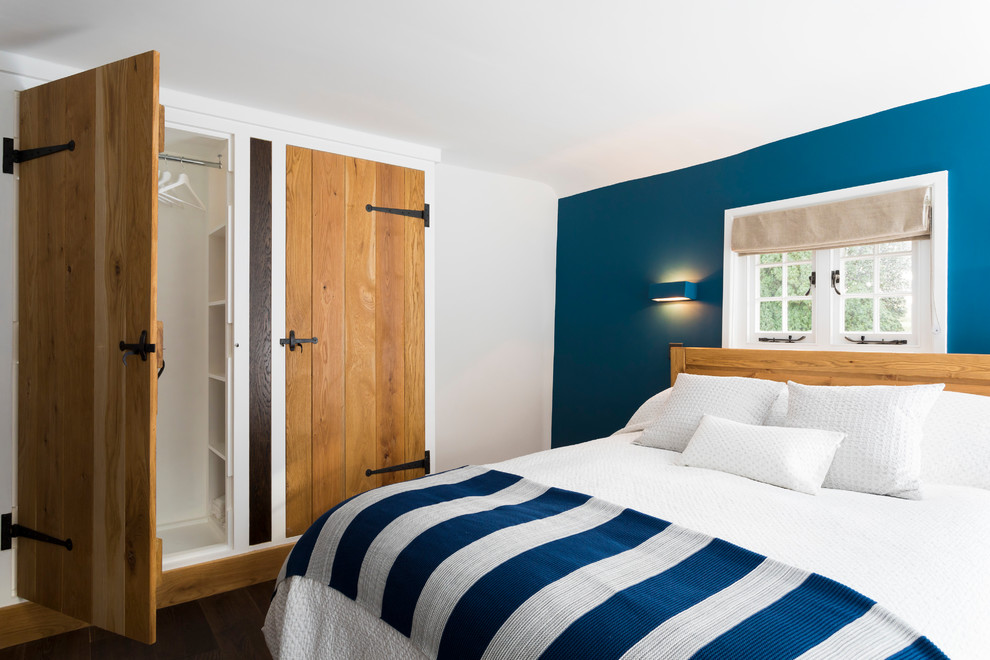 Imagen de dormitorio principal mediterráneo de tamaño medio con paredes azules y suelo de madera oscura