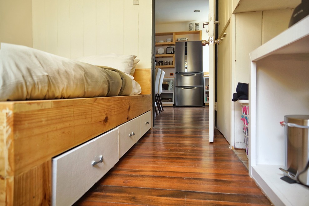 Immagine di una piccola camera matrimoniale stile americano con pareti bianche e pavimento in legno massello medio