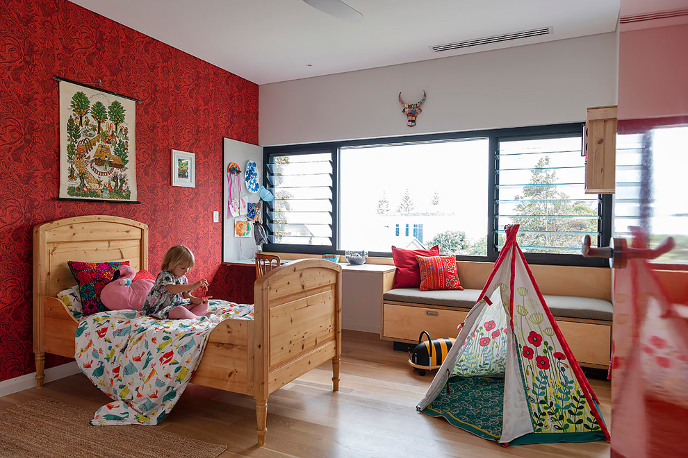 Ejemplo de dormitorio retro de tamaño medio con paredes rojas y suelo de madera clara