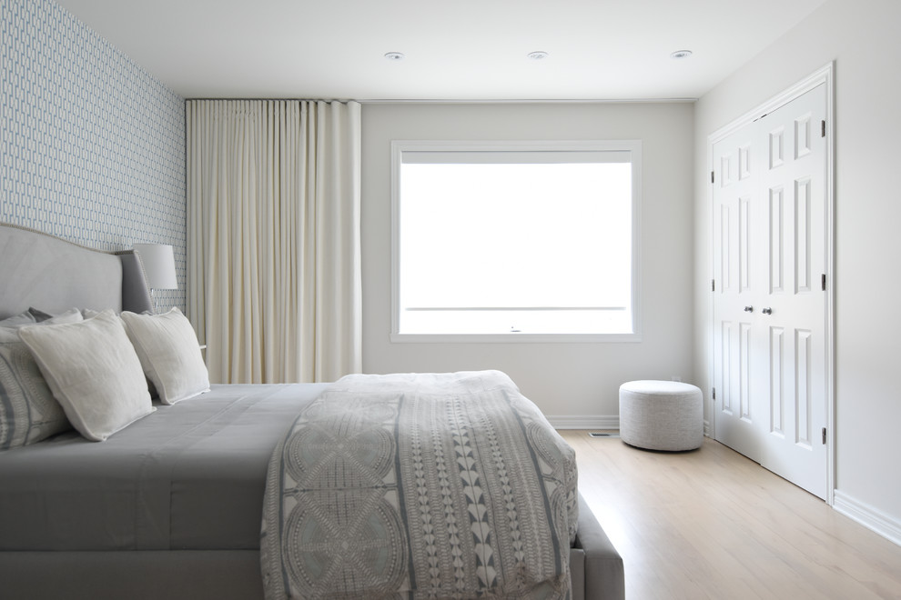 Modelo de dormitorio principal escandinavo de tamaño medio sin chimenea con paredes multicolor, suelo de madera clara y suelo marrón