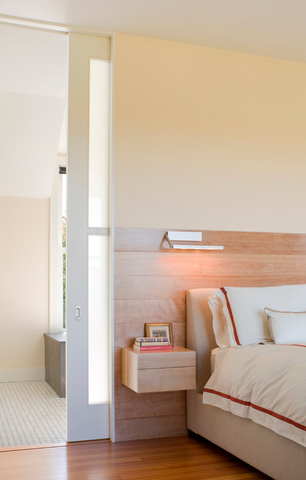 Imagen de dormitorio actual con paredes beige y suelo de madera en tonos medios