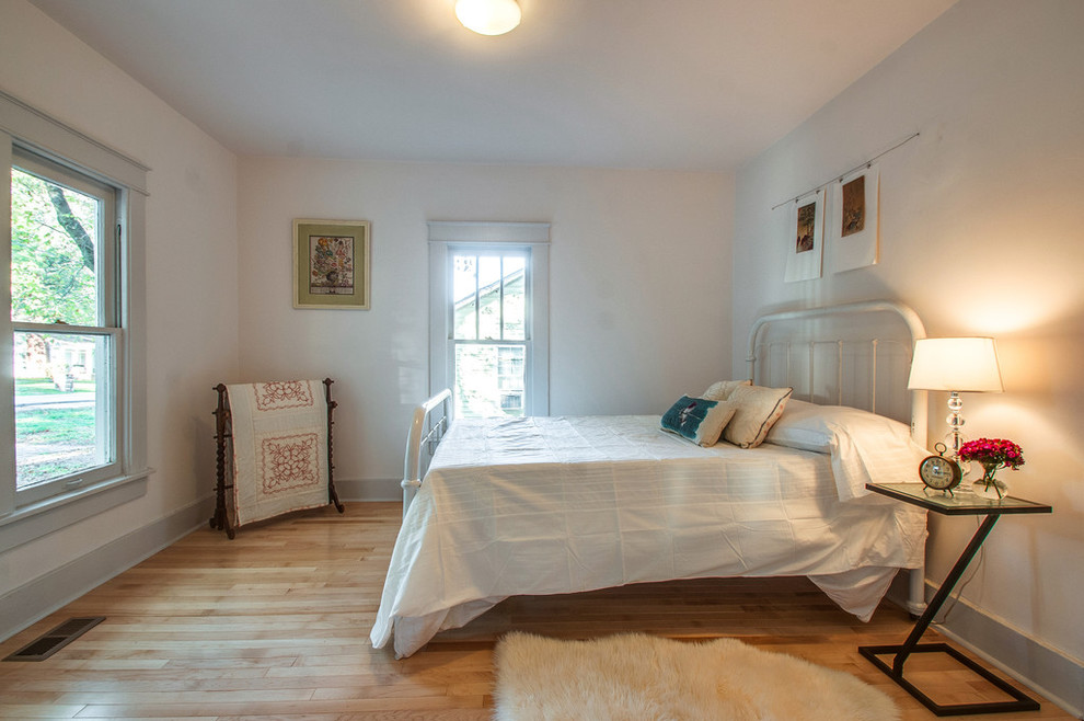 Foto de dormitorio de estilo americano pequeño con paredes blancas y suelo de madera clara