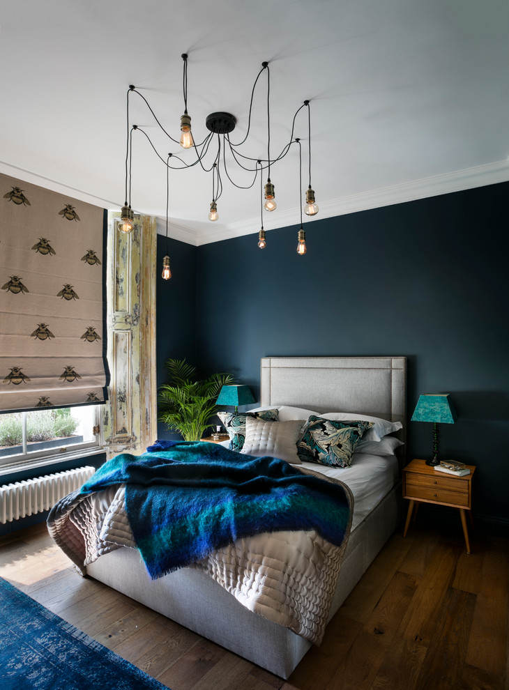 Design ideas for an eclectic master bedroom in London with blue walls and dark hardwood flooring.