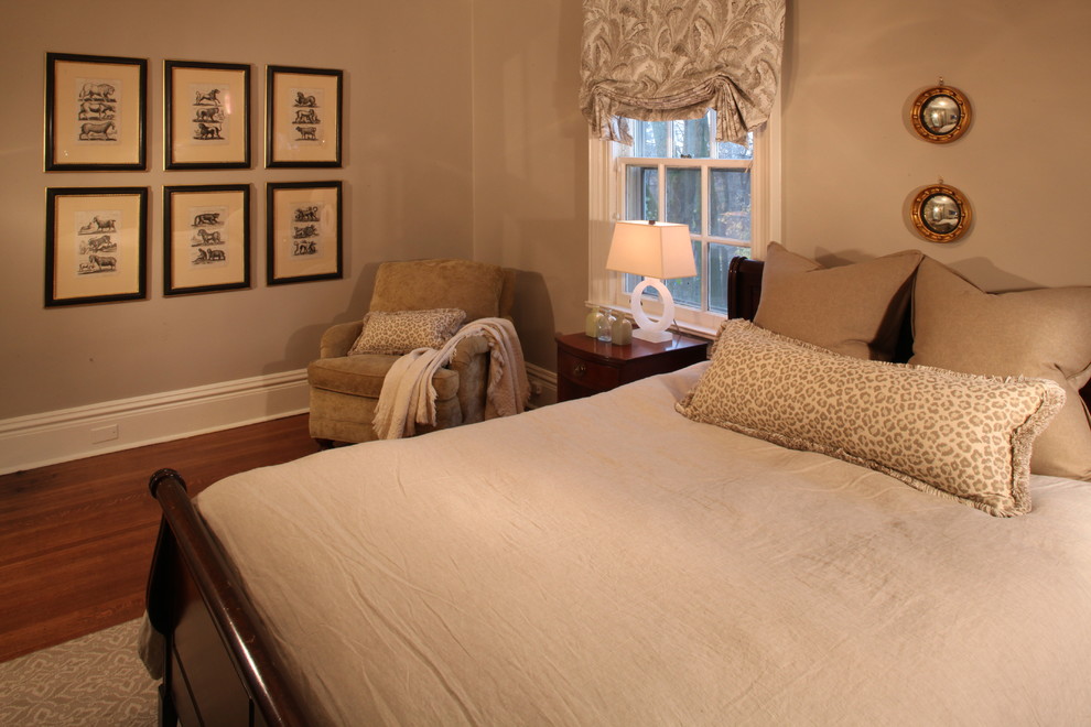 Immagine di una grande camera degli ospiti chic con pareti beige e pavimento in legno massello medio