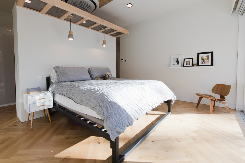 Retro Hauptschlafzimmer mit weißer Wandfarbe, braunem Holzboden und braunem Boden in Sonstige