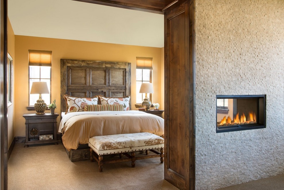 Diseño de dormitorio clásico con moqueta, chimenea de doble cara y marco de chimenea de piedra