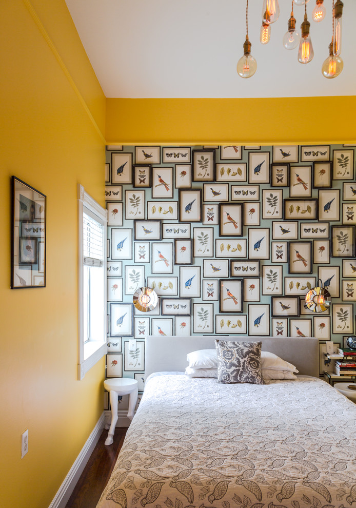 Ejemplo de dormitorio principal bohemio de tamaño medio con paredes amarillas y suelo de madera en tonos medios