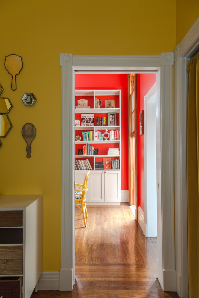 Idées déco pour une chambre parentale éclectique de taille moyenne avec un mur jaune et un sol en bois brun.