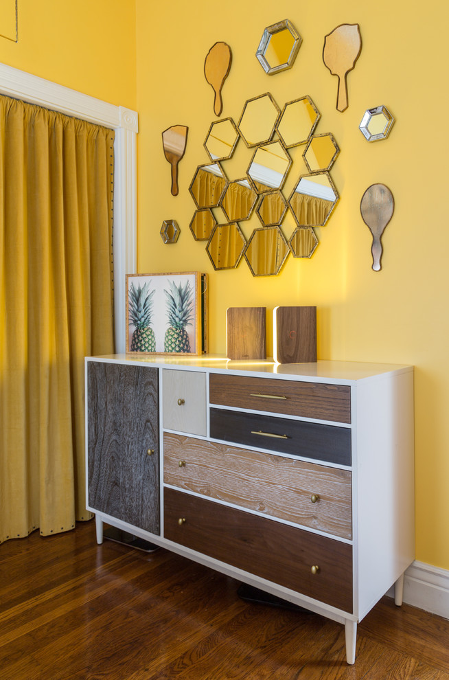 Diseño de dormitorio principal bohemio de tamaño medio con paredes amarillas y suelo de madera en tonos medios