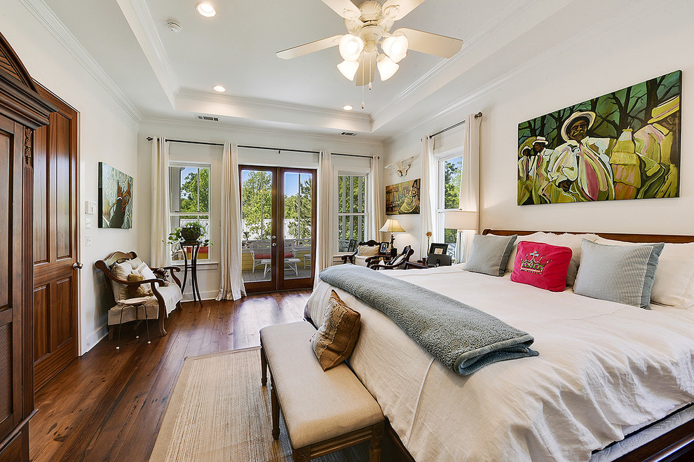 Foto di una camera matrimoniale tropicale con pareti bianche e pavimento in legno massello medio