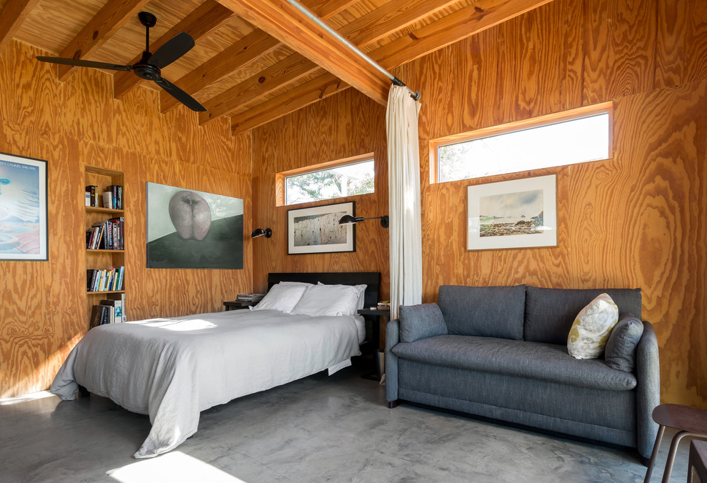 На фото: спальня в стиле лофт с бетонным полом и зонированием шторами