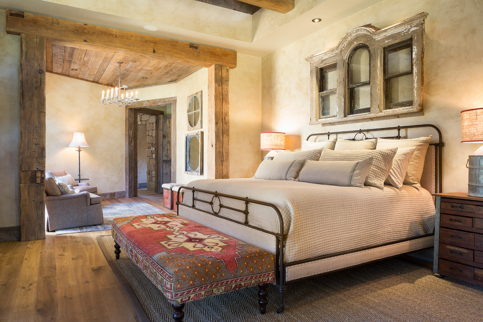 Ejemplo de dormitorio rústico con paredes beige y suelo de madera en tonos medios