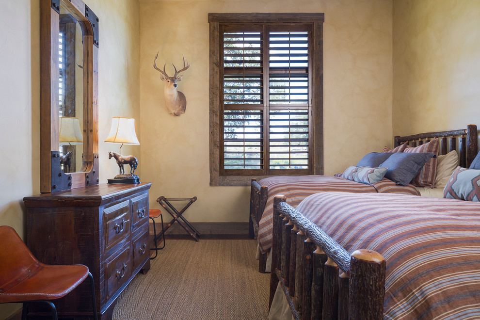 Rustic guest bedroom in Austin with beige walls.