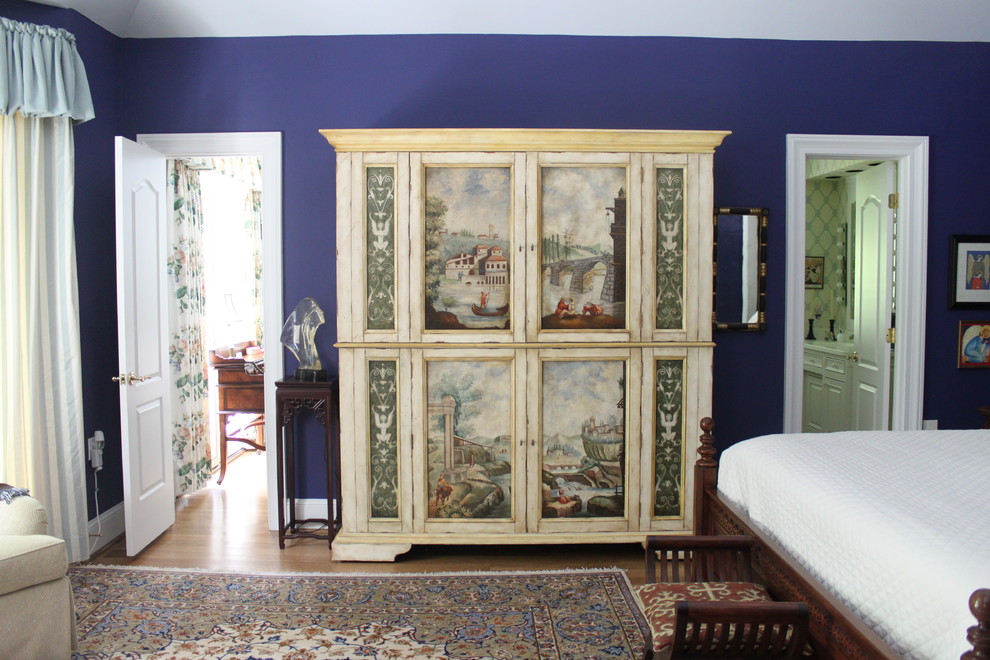 Modelo de dormitorio principal bohemio grande con paredes azules y suelo de madera clara