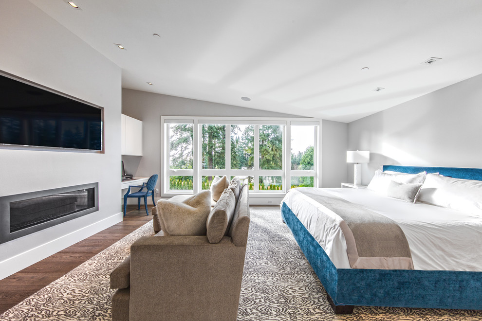 Стильный дизайн: большая хозяйская спальня в современном стиле с серыми стенами, паркетным полом среднего тона, горизонтальным камином и фасадом камина из металла - последний тренд