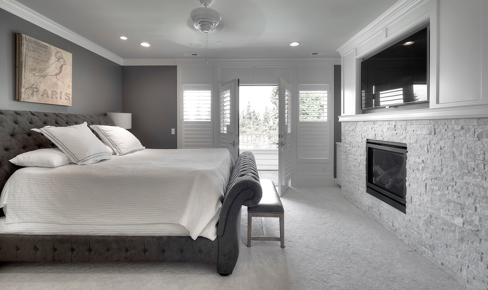 Свежая идея для дизайна: большая хозяйская спальня в стиле неоклассика (современная классика) с серыми стенами, ковровым покрытием, стандартным камином и фасадом камина из камня - отличное фото интерьера