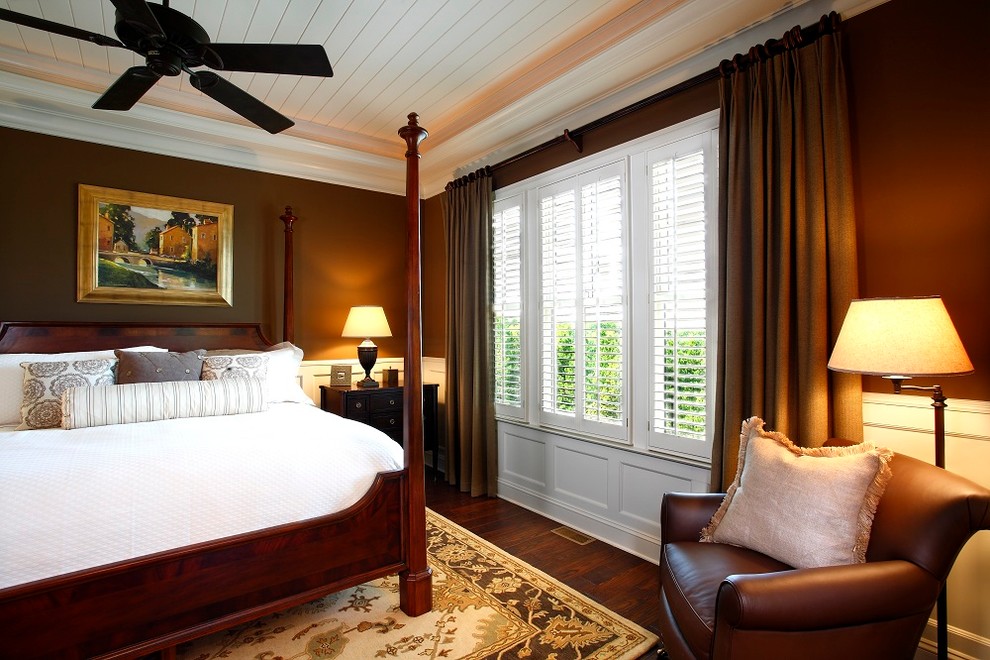 На фото: спальня в классическом стиле с коричневыми стенами и темным паркетным полом без камина