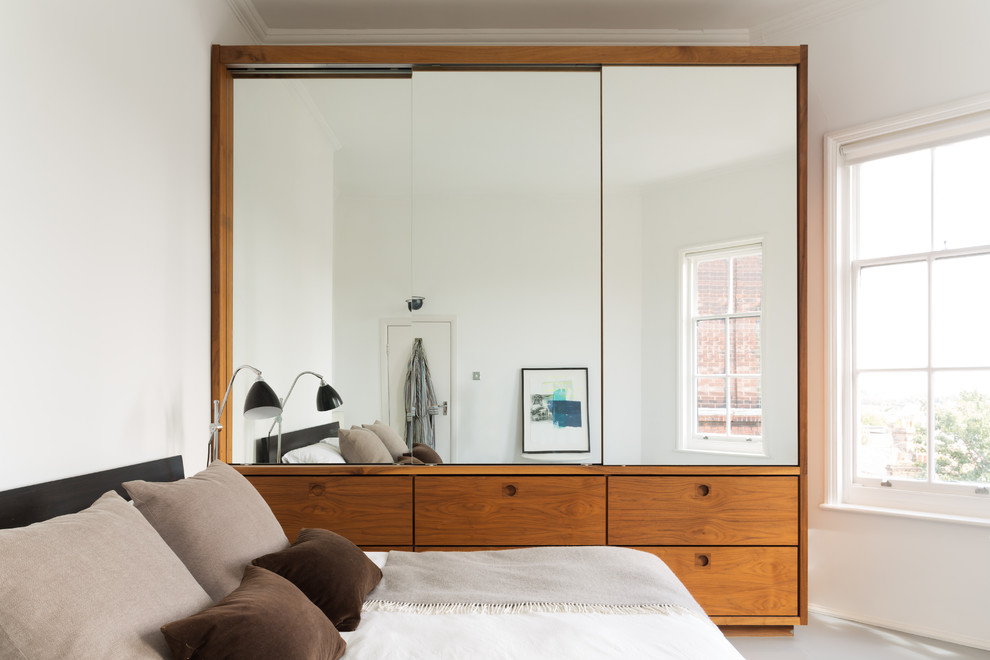 Example of a mid-sized danish master bedroom design in London with white walls