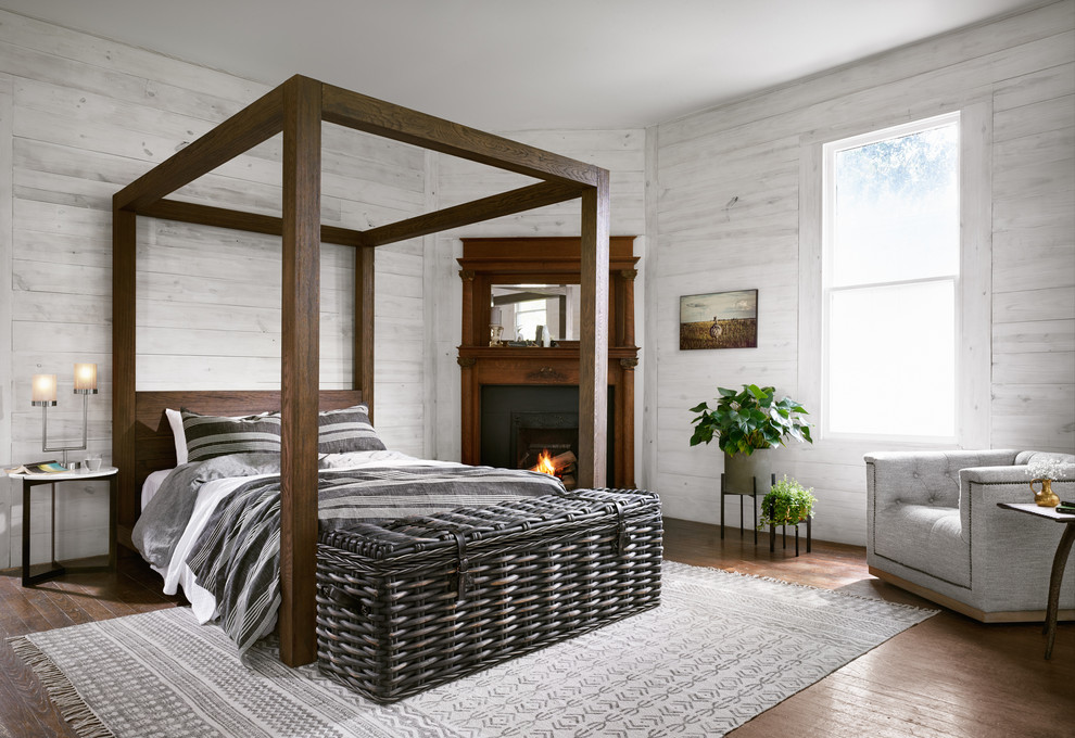 Bild på ett vintage sovrum, med vita väggar, mellanmörkt trägolv, en standard öppen spis och brunt golv