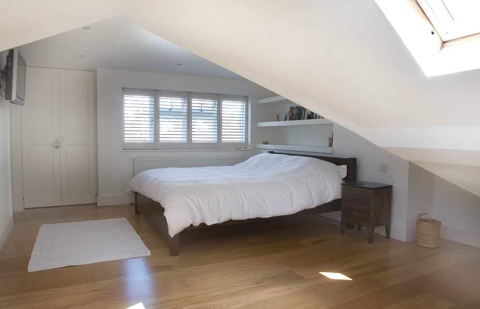 Design ideas for a medium sized contemporary mezzanine bedroom in London with medium hardwood flooring.