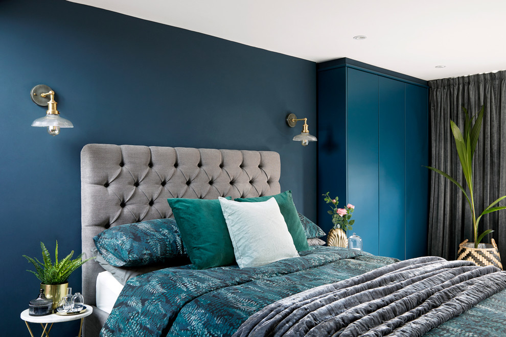 This is an example of a scandinavian master bedroom in London with blue walls.