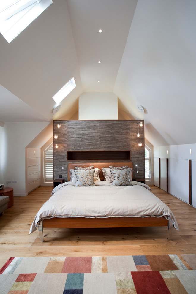Medium sized contemporary bedroom in London with white walls, light hardwood flooring and beige floors.