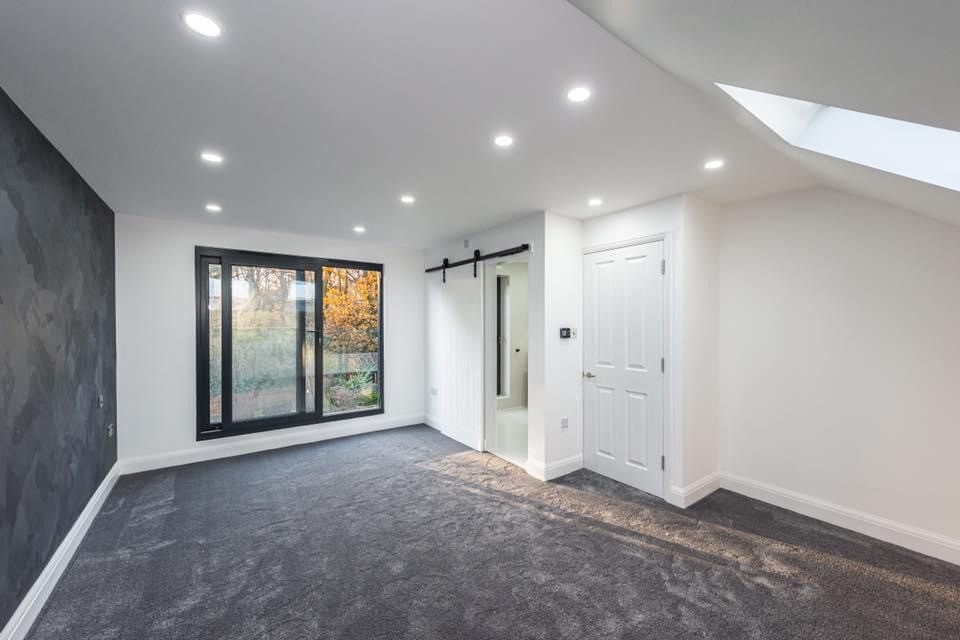 Großes Modernes Hauptschlafzimmer mit weißer Wandfarbe, Teppichboden und buntem Boden in London