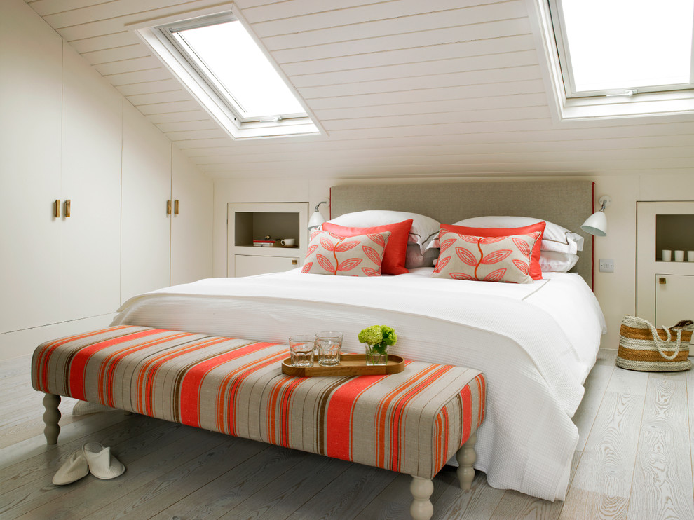 Ejemplo de habitación de invitados marinera con paredes blancas, suelo de madera clara, suelo beige y techo inclinado