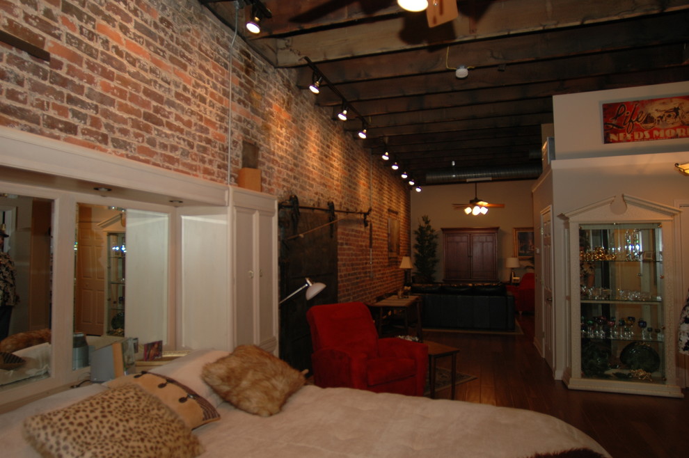 Industriell inredning av ett mellanstort huvudsovrum, med flerfärgade väggar, mörkt trägolv och brunt golv