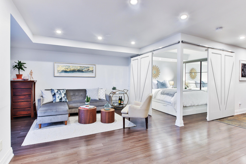 ロサンゼルスにある広いコンテンポラリースタイルのおしゃれなロフト寝室 (白い壁、無垢フローリング、暖炉なし、茶色い床) のインテリア