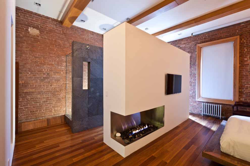 Foto de dormitorio moderno con suelo de madera en tonos medios y chimenea de esquina