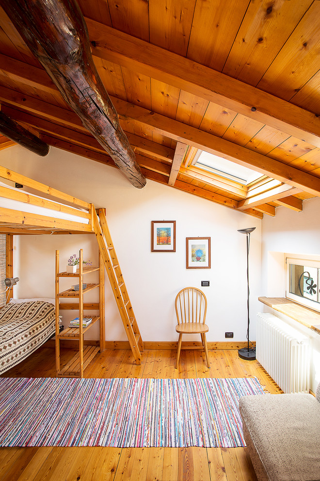 Imagen de habitación de invitados rural con paredes blancas y suelo de madera en tonos medios
