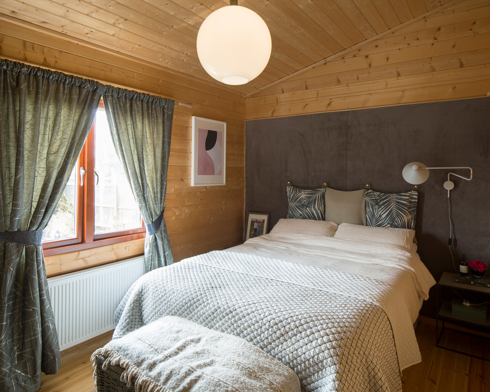 Small rustic bedroom in Buckinghamshire with beige walls, light hardwood flooring and beige floors.