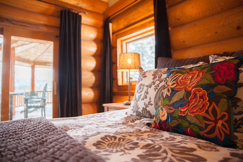 Foto de dormitorio principal rural grande sin chimenea con paredes marrones, suelo de madera en tonos medios y suelo marrón