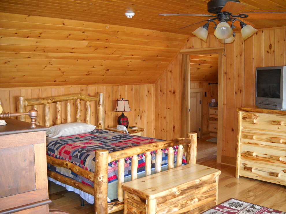 Ispirazione per una camera da letto stile rurale con pareti beige e parquet chiaro