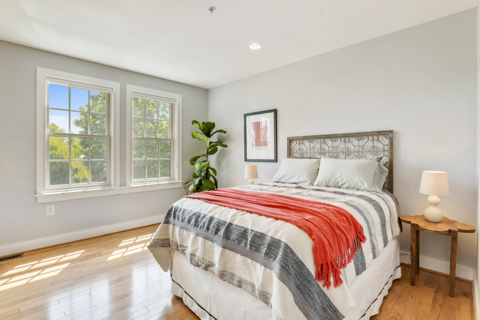Example of a large transitional medium tone wood floor and brown floor bedroom design in DC Metro with gray walls