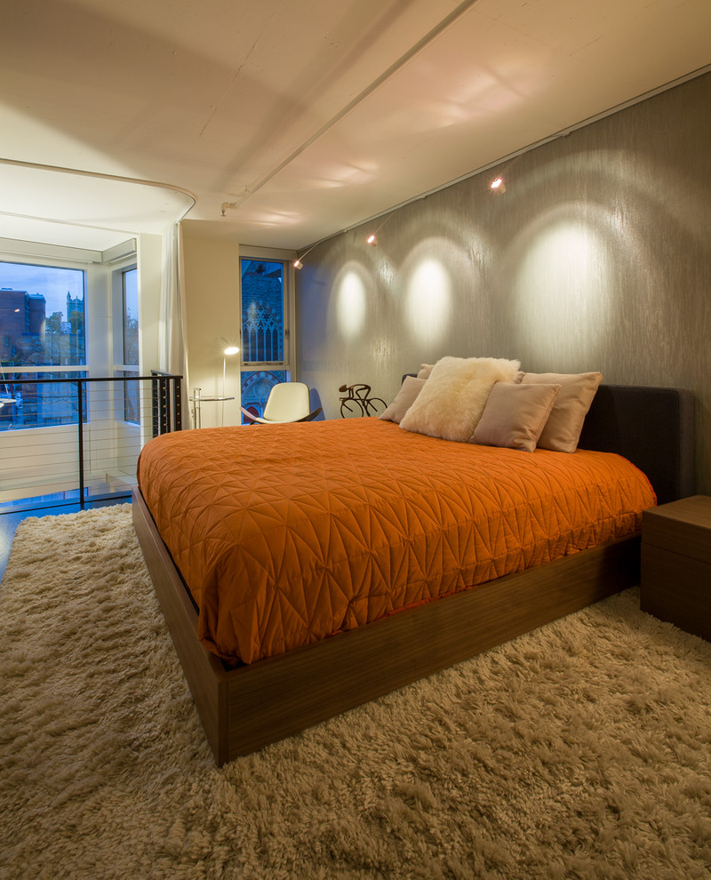 Foto di una piccola camera da letto stile loft moderna con pareti grigie e parquet scuro