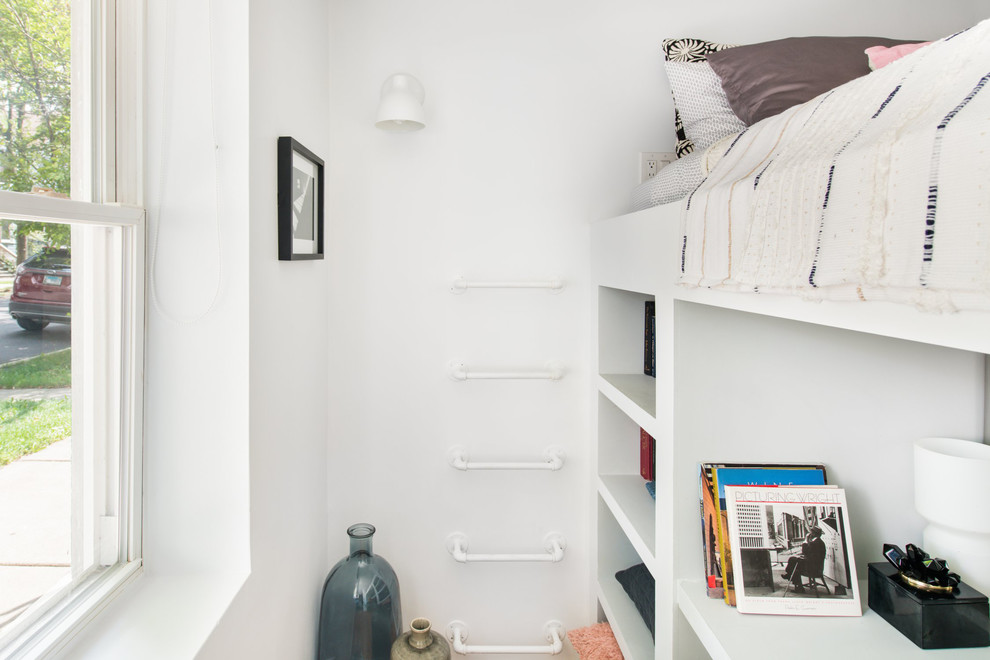Exemple d'une petite chambre mansardée ou avec mezzanine moderne avec un mur blanc, parquet clair et un sol marron.