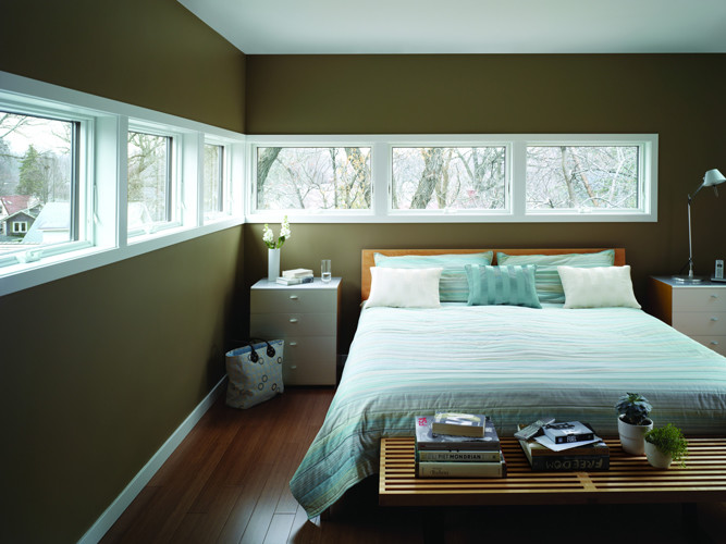 На фото: хозяйская спальня среднего размера в современном стиле с зелеными стенами и паркетным полом среднего тона без камина
