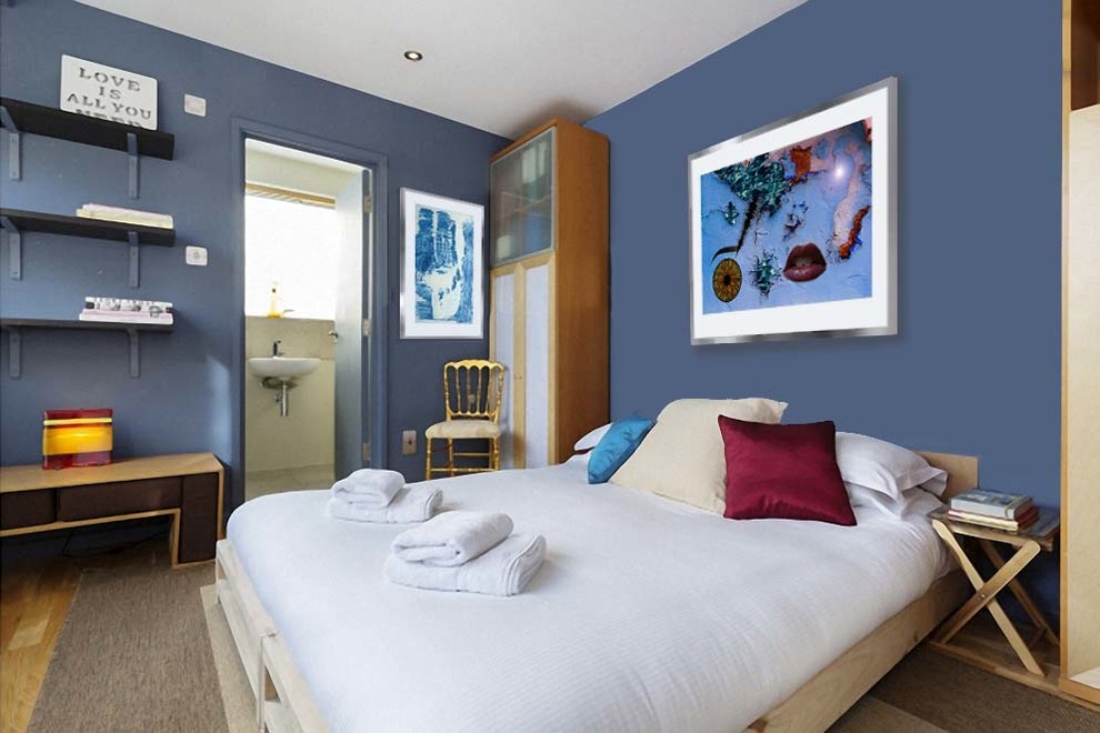 Diseño de habitación de invitados contemporánea de tamaño medio con paredes azules, suelo de madera clara y suelo marrón