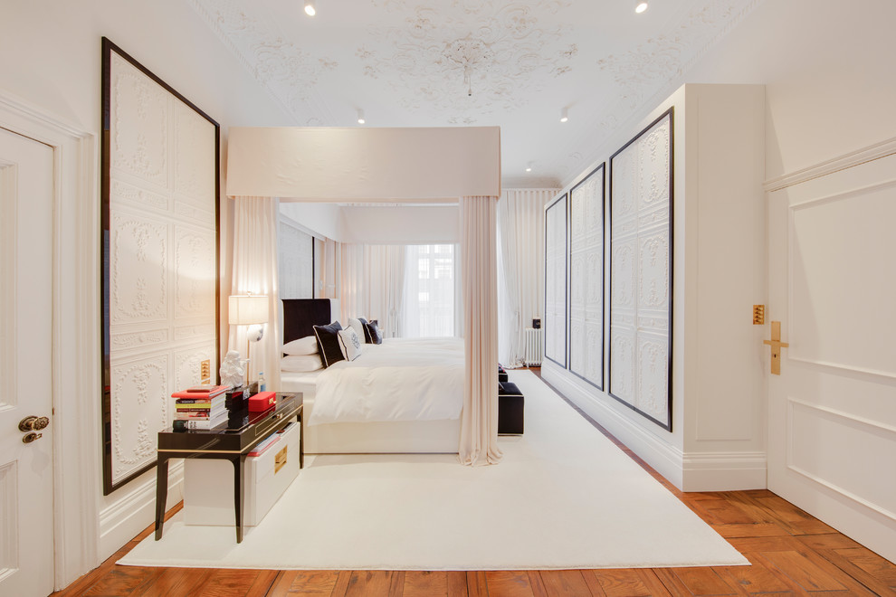 This is an example of a large classic bedroom in London with white walls, light hardwood flooring and brown floors.