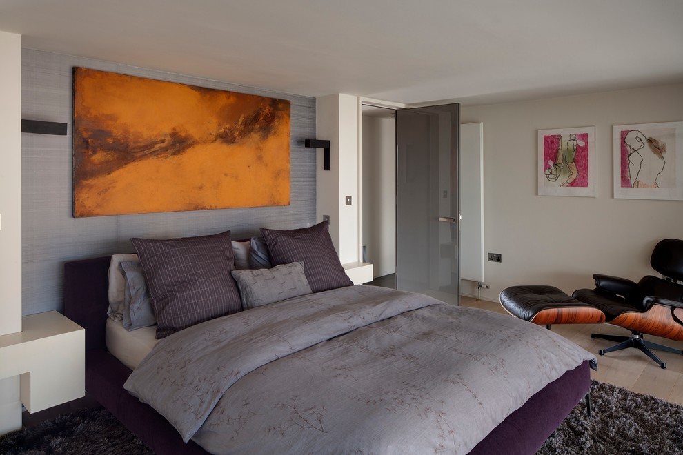 Photo of a contemporary grey and brown bedroom in London with grey walls and light hardwood flooring.