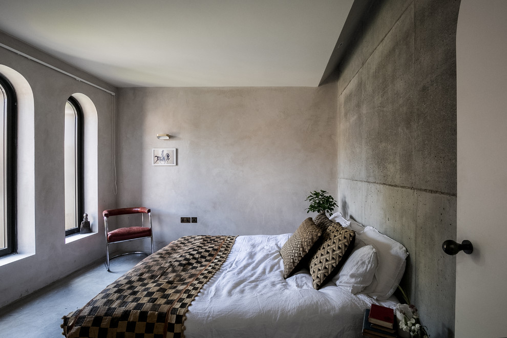 Idée de décoration pour une chambre parentale méditerranéenne avec un mur gris, sol en béton ciré et un sol gris.