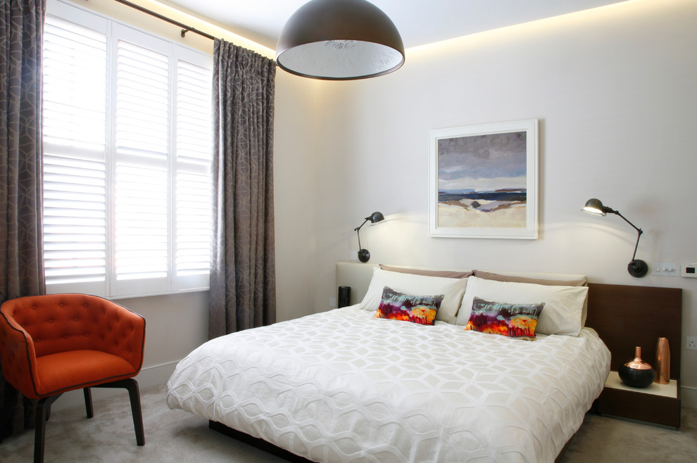 Immagine di una camera matrimoniale minimalista di medie dimensioni con pareti beige e moquette