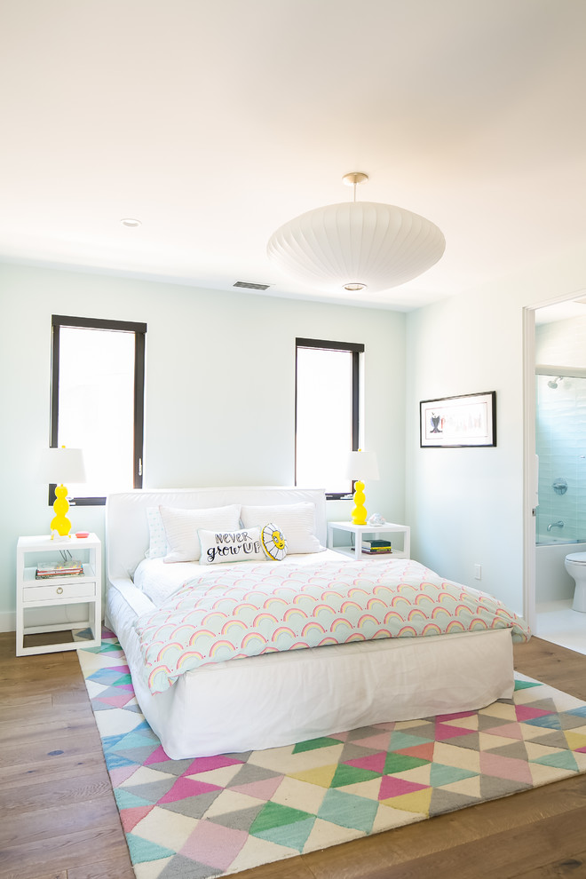 Diseño de habitación de invitados minimalista grande sin chimenea con paredes azules, suelo de madera clara y suelo beige