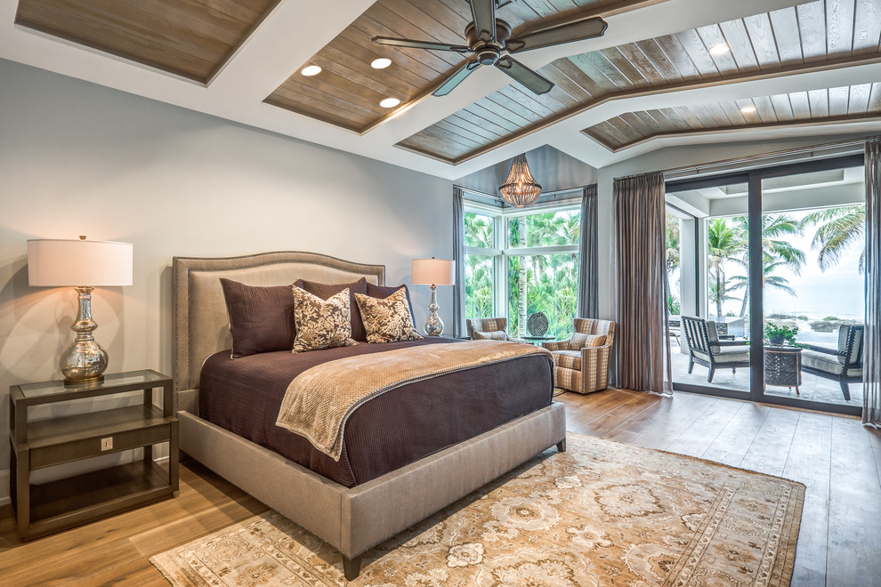 Ejemplo de dormitorio principal tradicional renovado extra grande sin chimenea con paredes grises, suelo de madera en tonos medios y suelo marrón