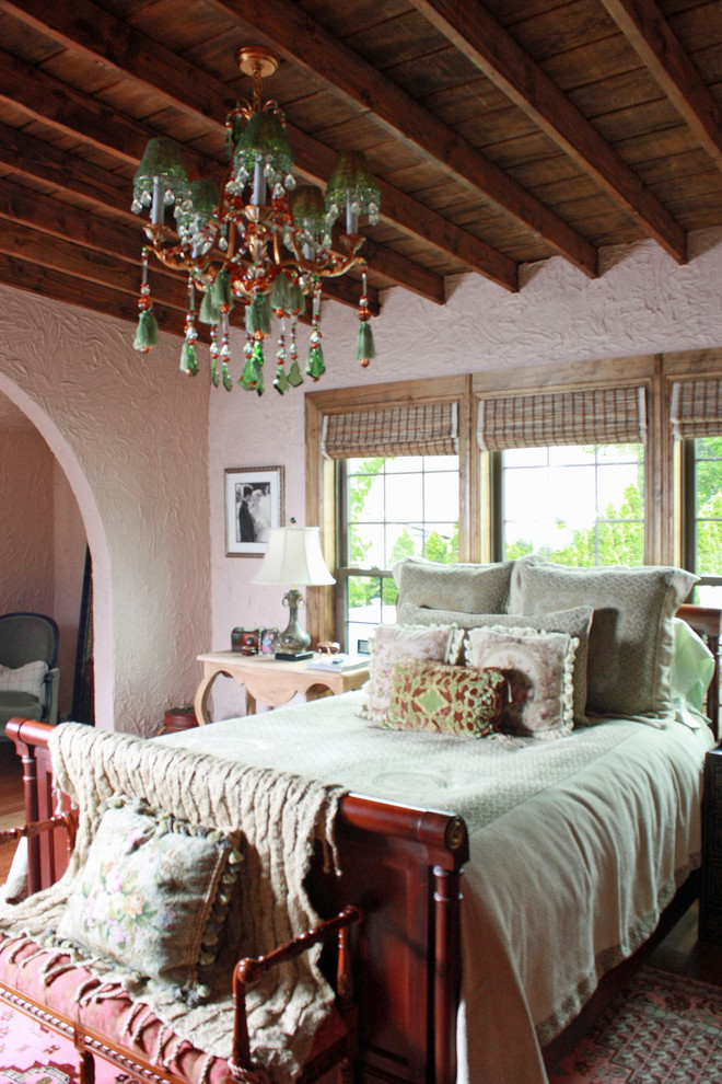 Foto di una grande camera matrimoniale mediterranea con pareti rosa, pavimento in legno massello medio e camino classico