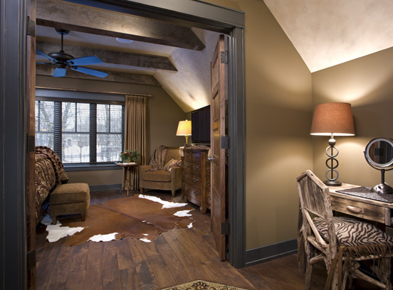 Foto di una grande camera degli ospiti classica con pavimento in legno massello medio, pareti marroni e nessun camino