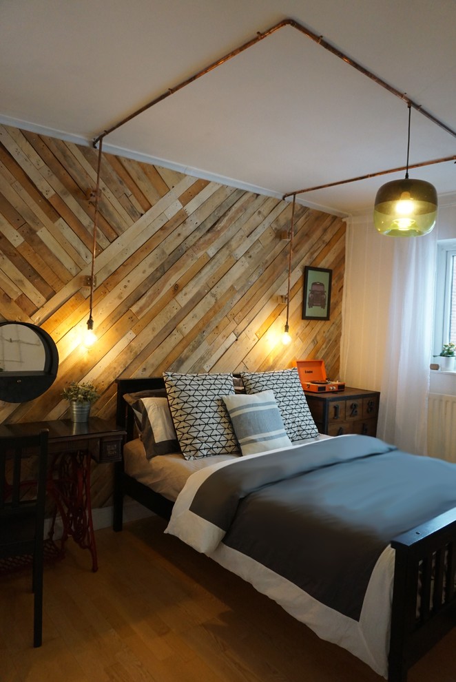Ejemplo de habitación de invitados urbana grande con suelo de madera en tonos medios y paredes blancas